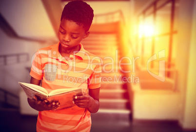 Composite image of cute boy reading book in library