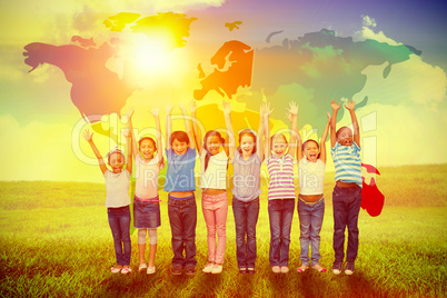 Composite image of cute pupils smiling at camera in classroom