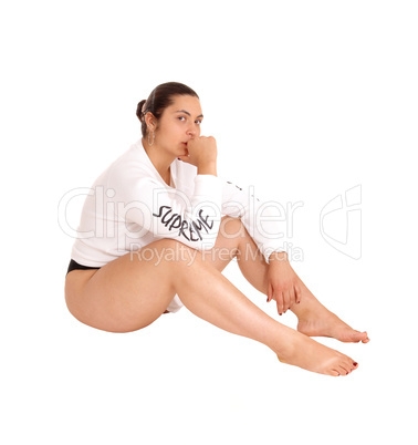 Woman in white shirt sitting on floor.