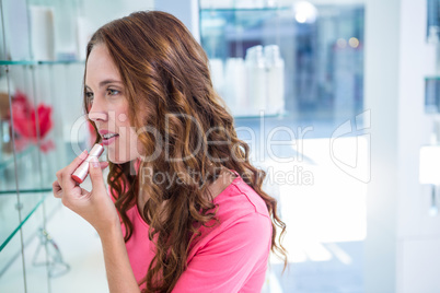 Pretty woman trying a lipstick