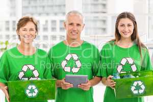 Smiling eco-minded colleagues with recycling boxes