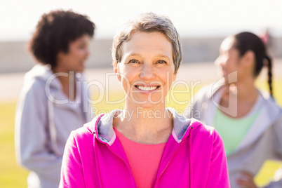 Smiling sporty woman in front of friends