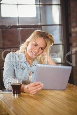 Smiling blonde holding tablet computer