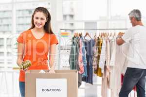 Smiling casual businesswoman sorting donations