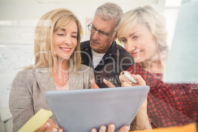 Smiling business team working over a tablet