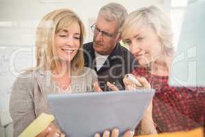 Smiling business team working over a tablet