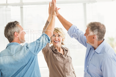 Smiling business colleagues giving high-five