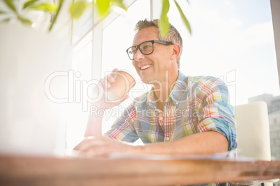Smiling casual designer drinking out of take-away cup