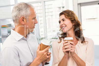 Smiling casual business colleagues having coffee together