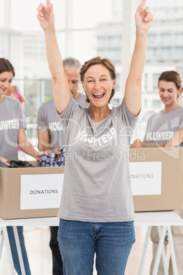 Cheering female volunteer in front of colleagues