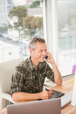 Smiling casual businessman having a phone call