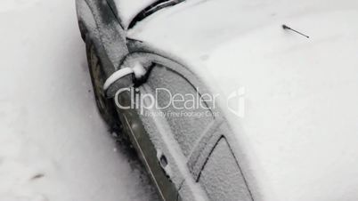 Snowfall covers car