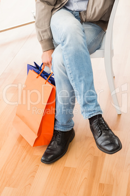 Man with shopping bags sitting and waiting