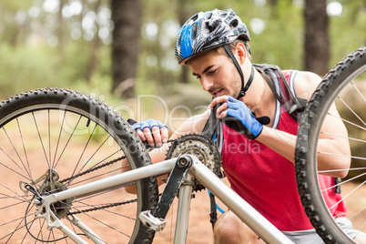 Happy handsome biker repairing bike