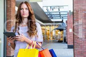 Pretty woman shopping at the mall using tablet