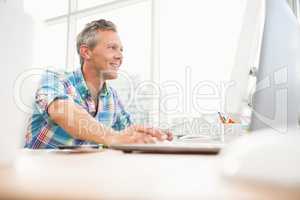 Smiling casual designer working with computer