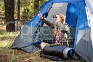 Blonde camper looking through binoculars