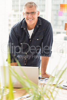 Smiling businessman working on a laptop