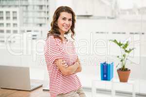 Smiling casual businesswoman with arms crossed