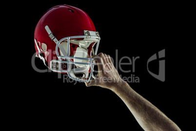 American football player holding up his helmet