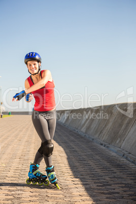 Carefree sporty blonde posing with inline skates