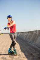 Carefree sporty blonde posing with inline skates