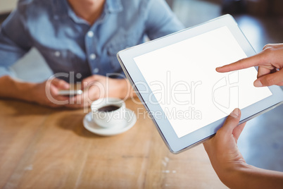 Smiling waitress using tablet pc