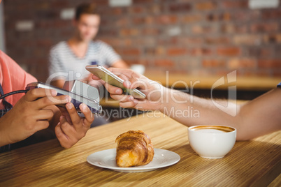 Paying for a croissant and a coffee with his smartphone