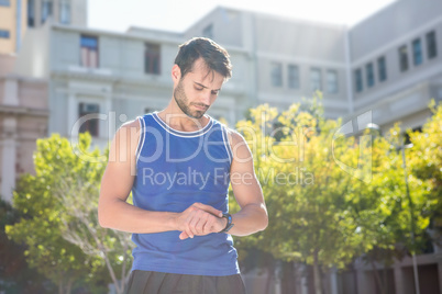 Focused handsome athlete setting heart rate watch