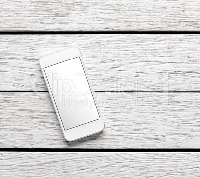 White smart phone on white wooden desk