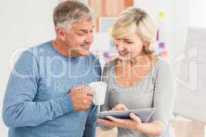 Smiling business colleagues working on a tablet