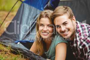 Portrait of a young happy couple lying in a tent