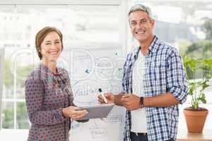 Smiling casual business colleagues with tablet