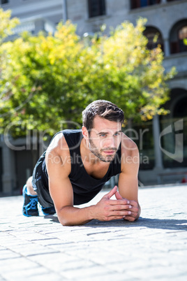 Handsome athlete doing a plank exercise