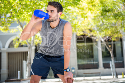 Handsome runner drinking fresh water