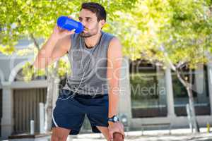 Handsome runner drinking fresh water