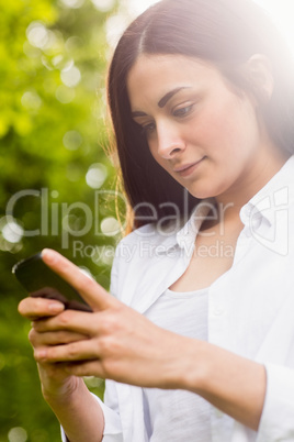 Beautiful brunette sending a text message