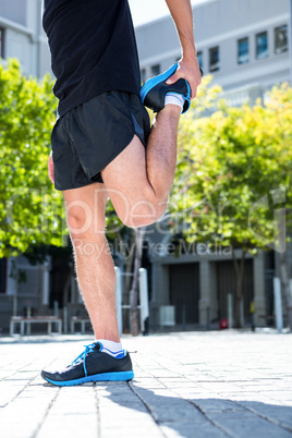 Athletic man doing a leg stretching