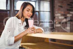 A beautiful woman drinking a pink milkshake