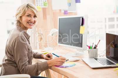 Smiling casual designer working with colour chart