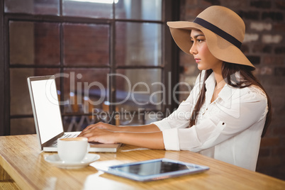 A businesswoman using her laptop while enjoying a coffee