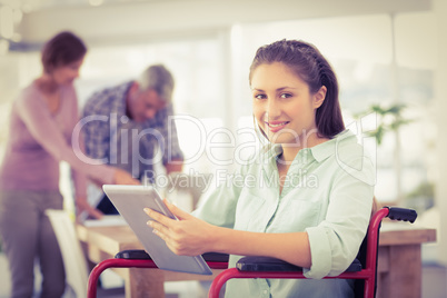 Casual businesswoman in wheelchair using tablet