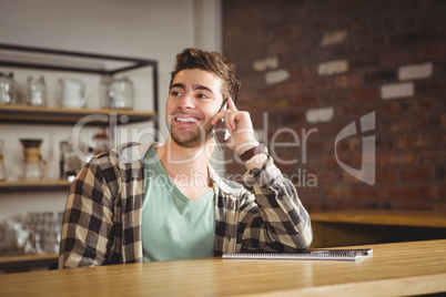 Smiling hipster phoning with smartphone