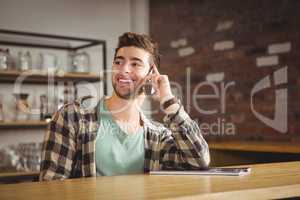 Smiling hipster phoning with smartphone