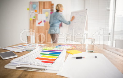 Rear view of a businesswoman writing on a white board