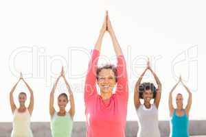 Smiling sporty woman doing yoga in yoga class