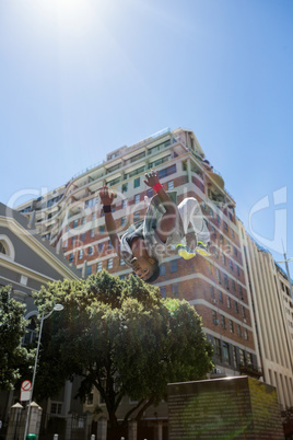 Athletic man doing back flip in the city