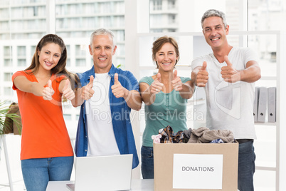 Casual business people donating and doing thumbs up