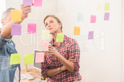 Casual business colleagues working with sticky notes