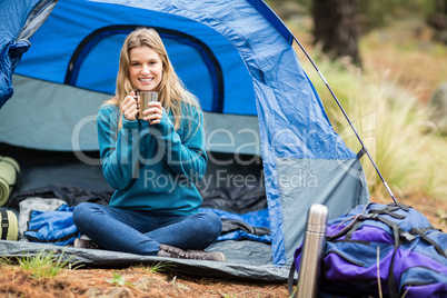 Portrait of a young pretty hiker sitting in a tent